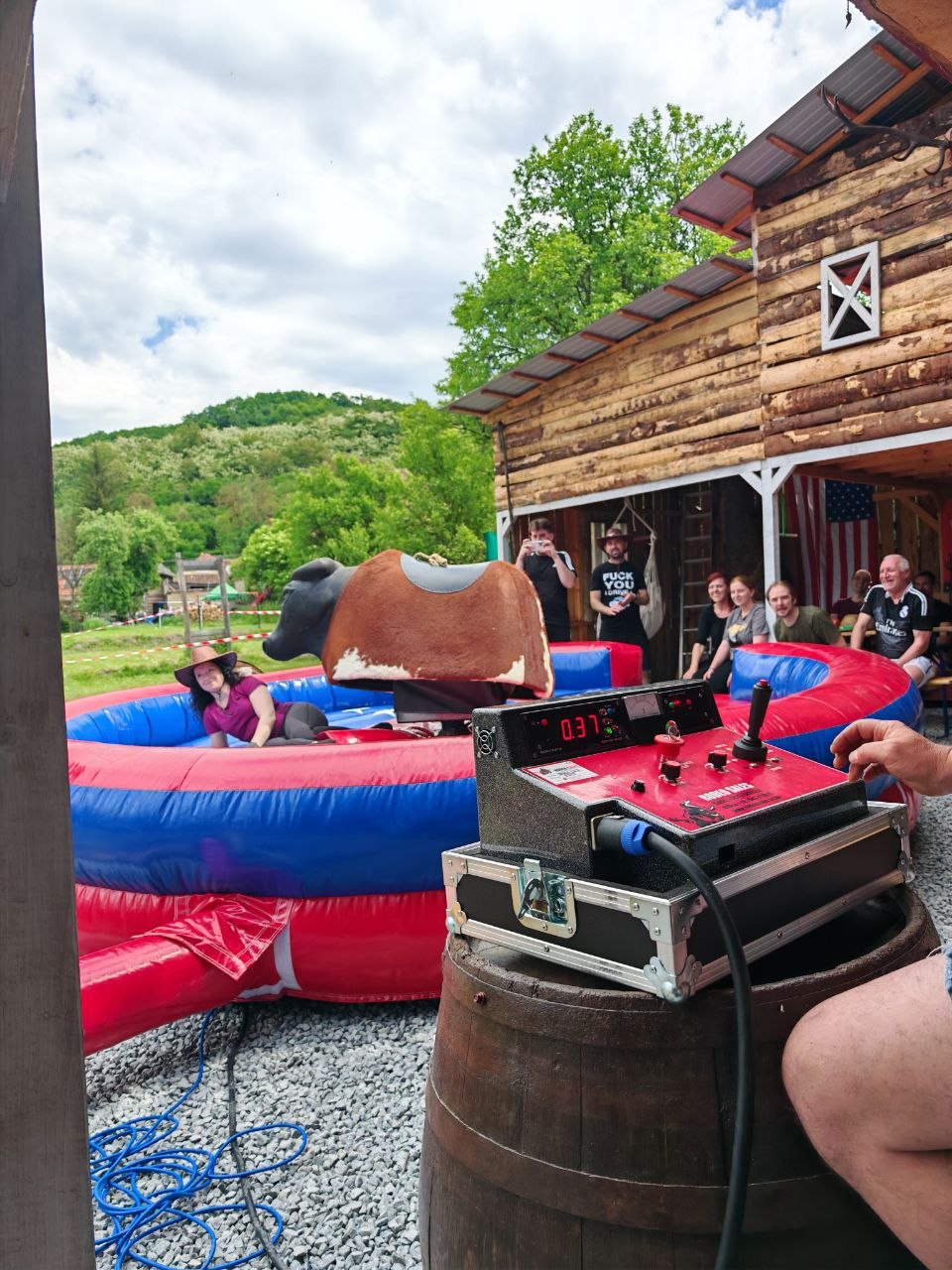 A funny mechanical bull moment as guests laugh and film during the Viessmann Transilvania sports day
