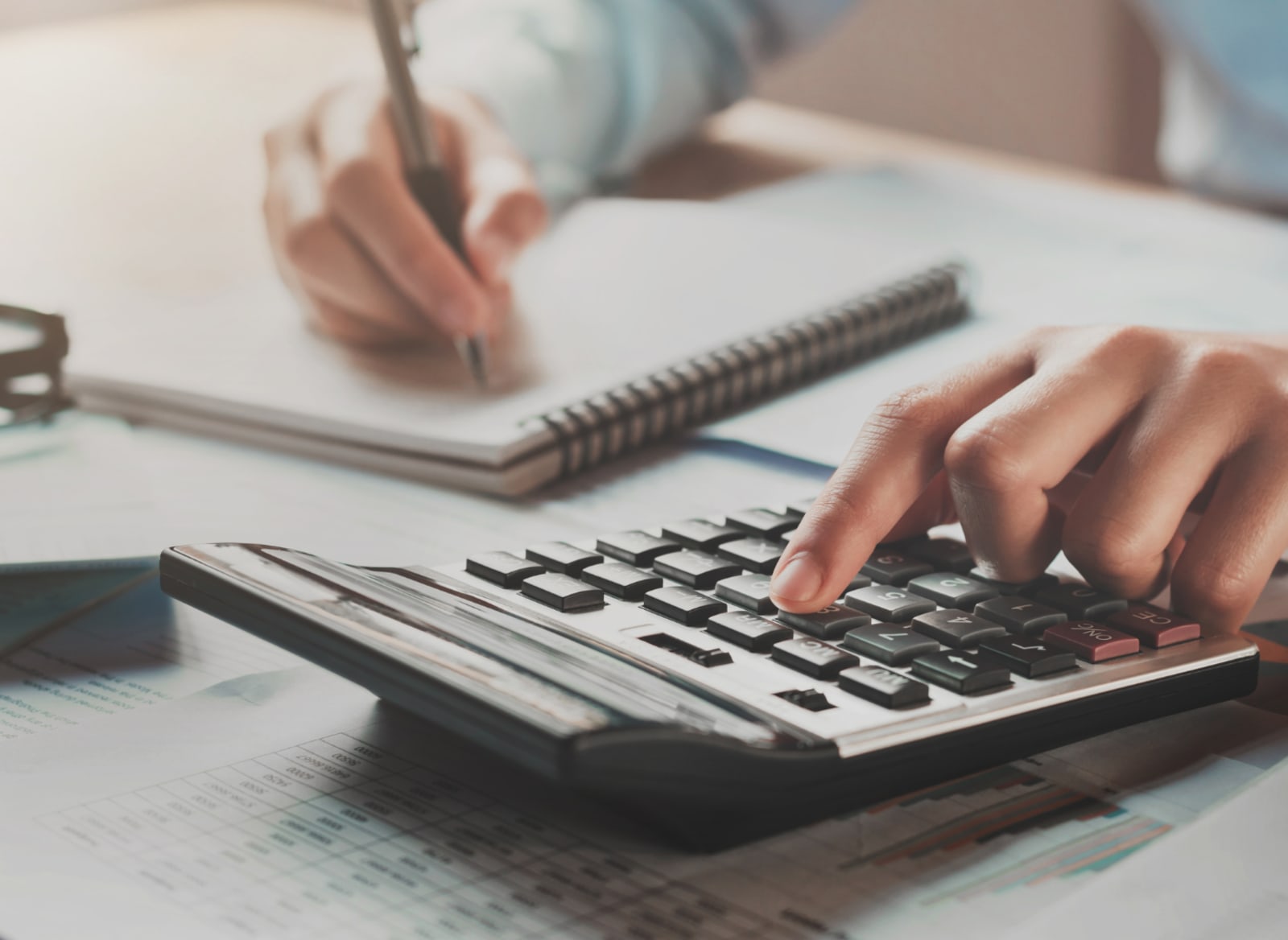 Hands using a calculator to estimate equity release