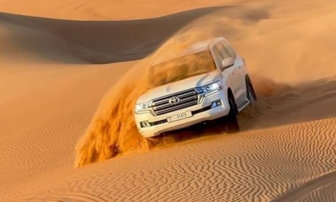 A Car Partially Buried Under The Shifting Sands Of The Dubai Desert, Showcasing The Wild And Untamed Nature Of Safari Adventures.