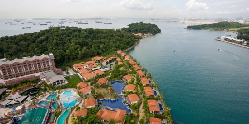 Aerial View Of The Equarius Hotel At Resorts World Sentosa Surrounded By Water.