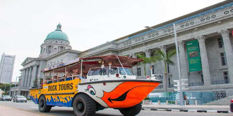 Amphibious DUCKtour Vehicle Cruising In Singapore, Offering A Unique Blend Of Land And Water Exploration To Its Passengers.