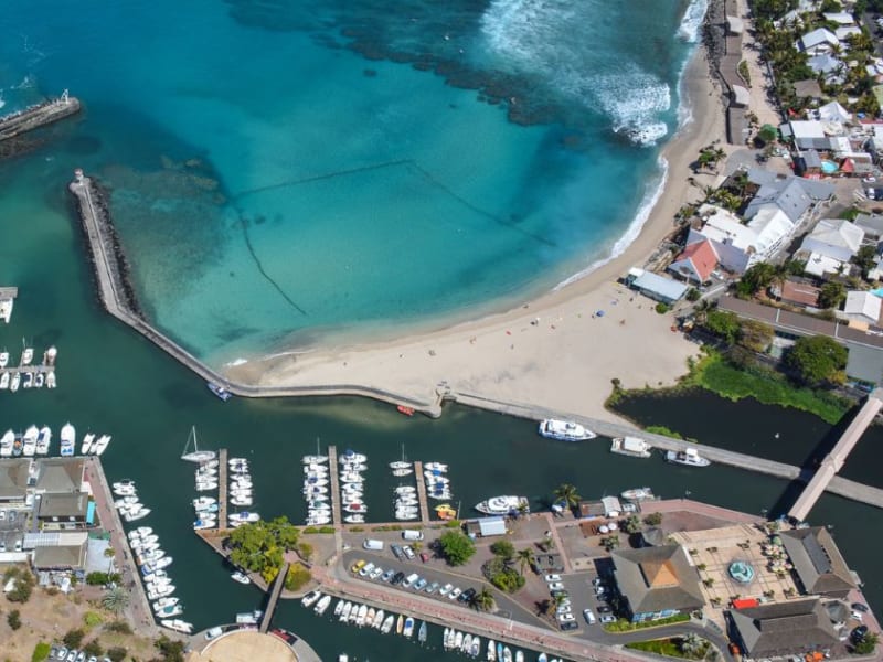 Port de plaisance de Saint-Gilles-les-Bains vu du ciel, digues, voiliers à quai et plage au bord de l'eau turquoise