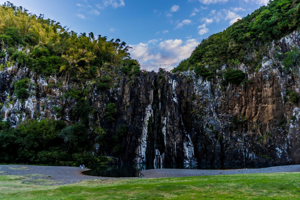 Niagara Waterfall in Sainte-Suzanne, Reunion Island, water dropping down a basalt cliff into an emerald pool