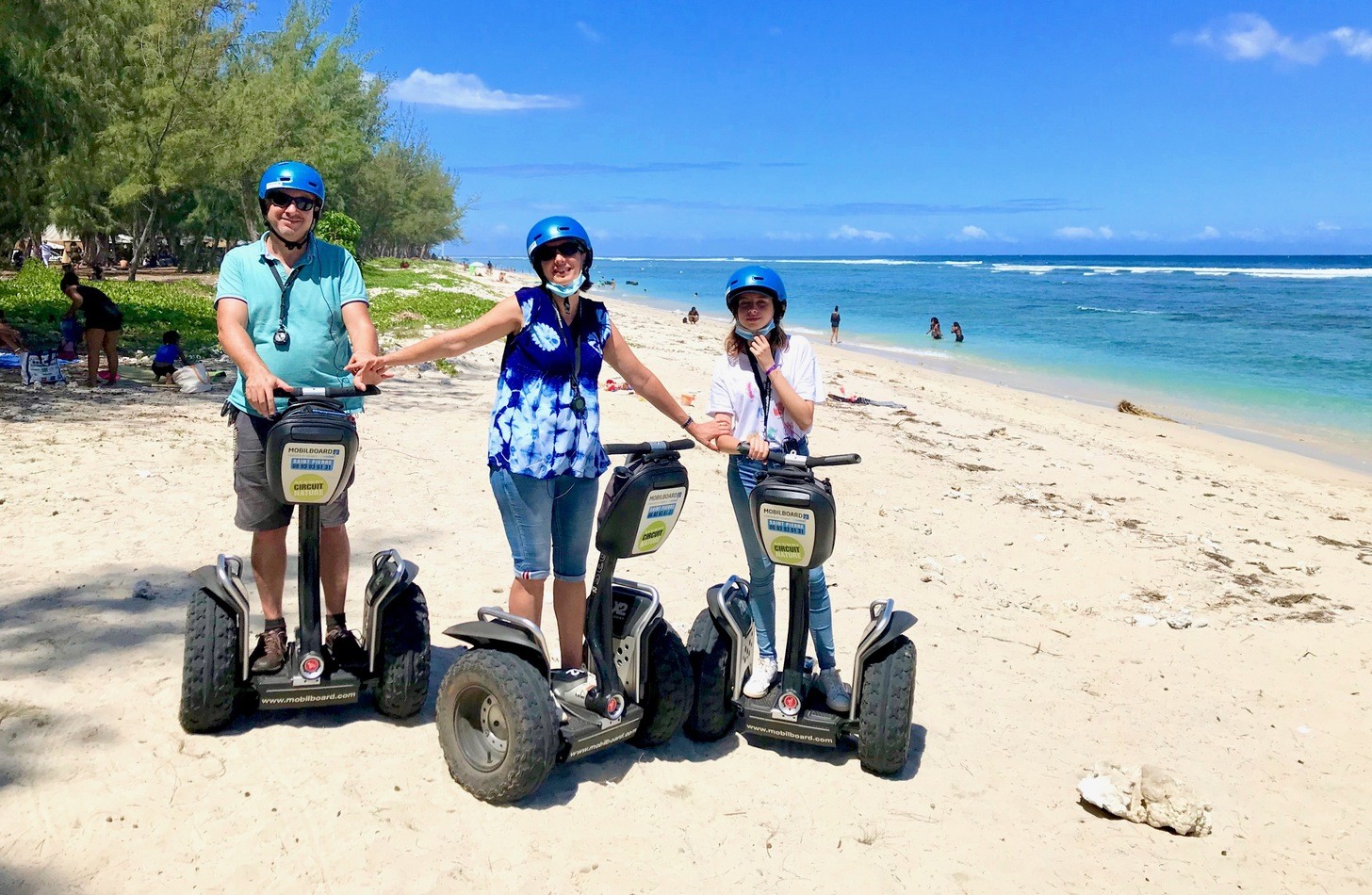 Famille en Segway sur la plage de l'Étang-Salé après la traversée de la forêt, lagon et bras de mer en arrière-plan, La Réunion