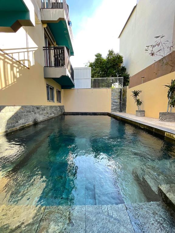 Piscine extérieure de l'Hôtel Select située entre deux bâtiments, eau turquoise et terrasse en pierre