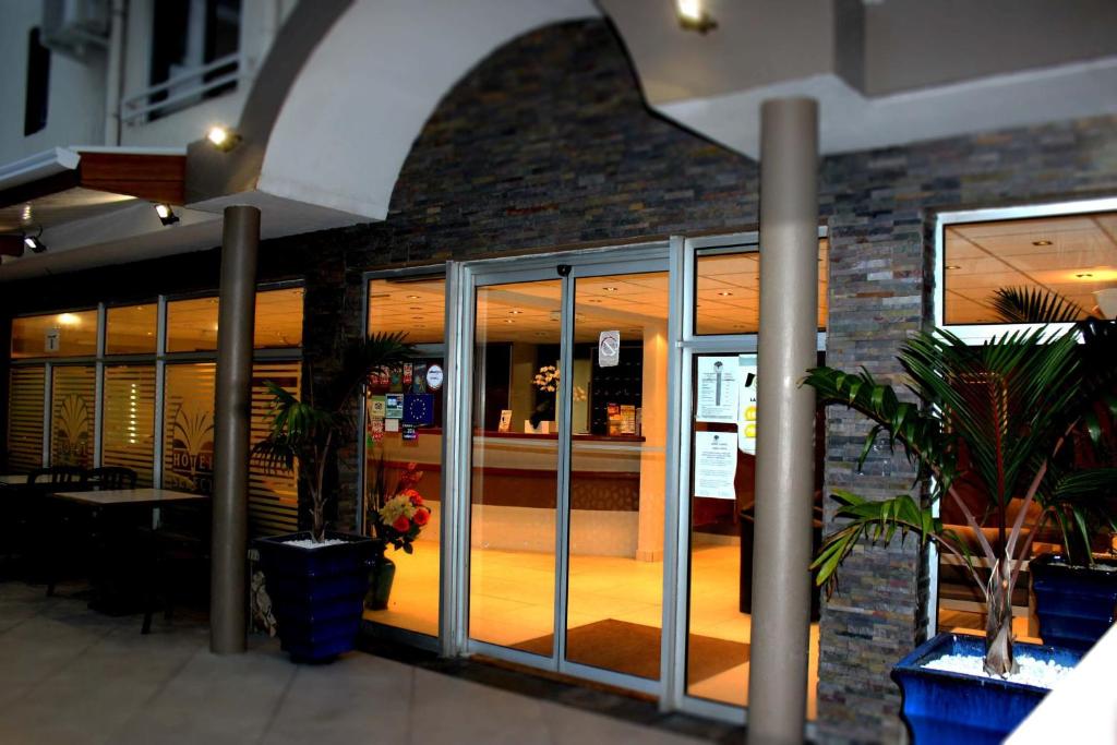 Réception nocturne de l'Hôtel Select avec arche illuminée, baies vitrées et plantes en pots bleus