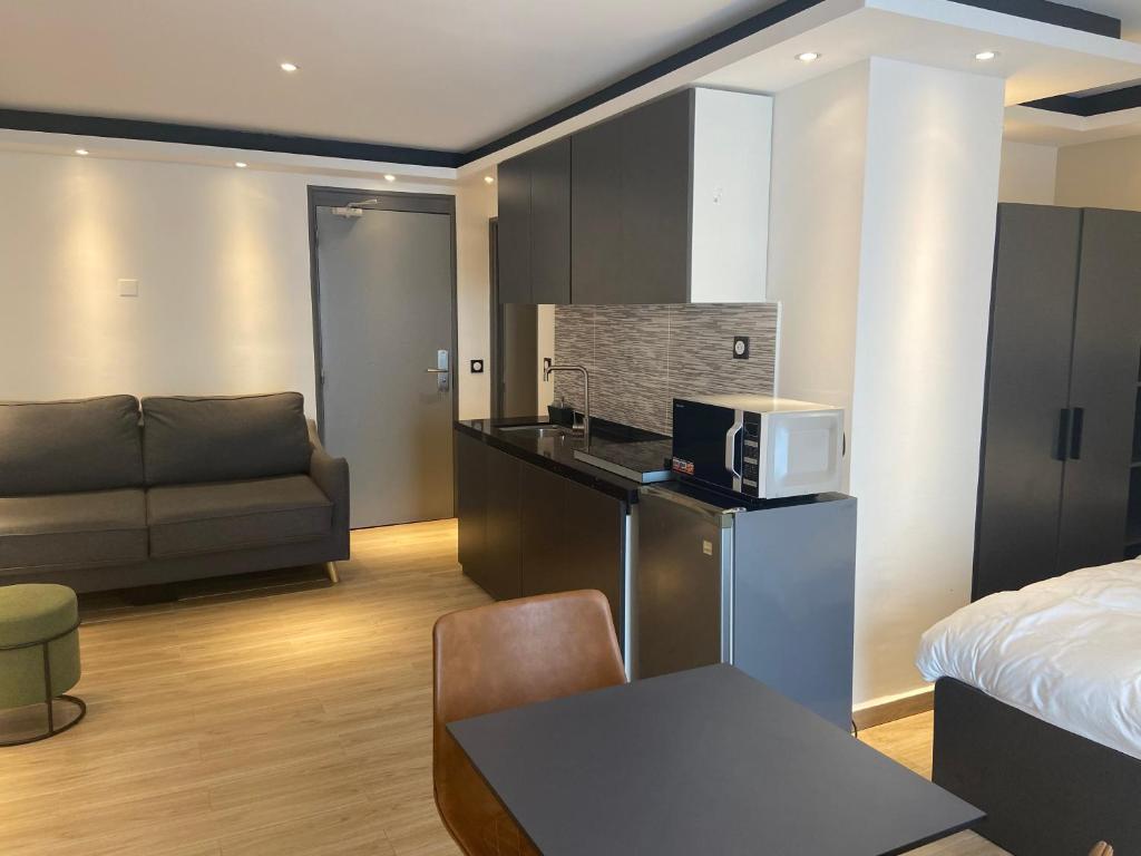 Studio kitchenette de l'Hôtel Select avec canapé, plan de travail, micro-ondes et coin nuit