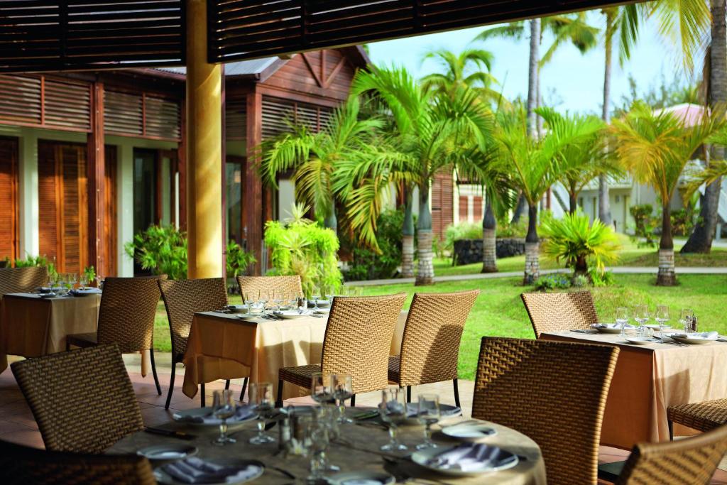 Restaurant Comptoir Sud de l'Hôtel Le Récif, terrasse couverte avec tables dressées et jardin tropical