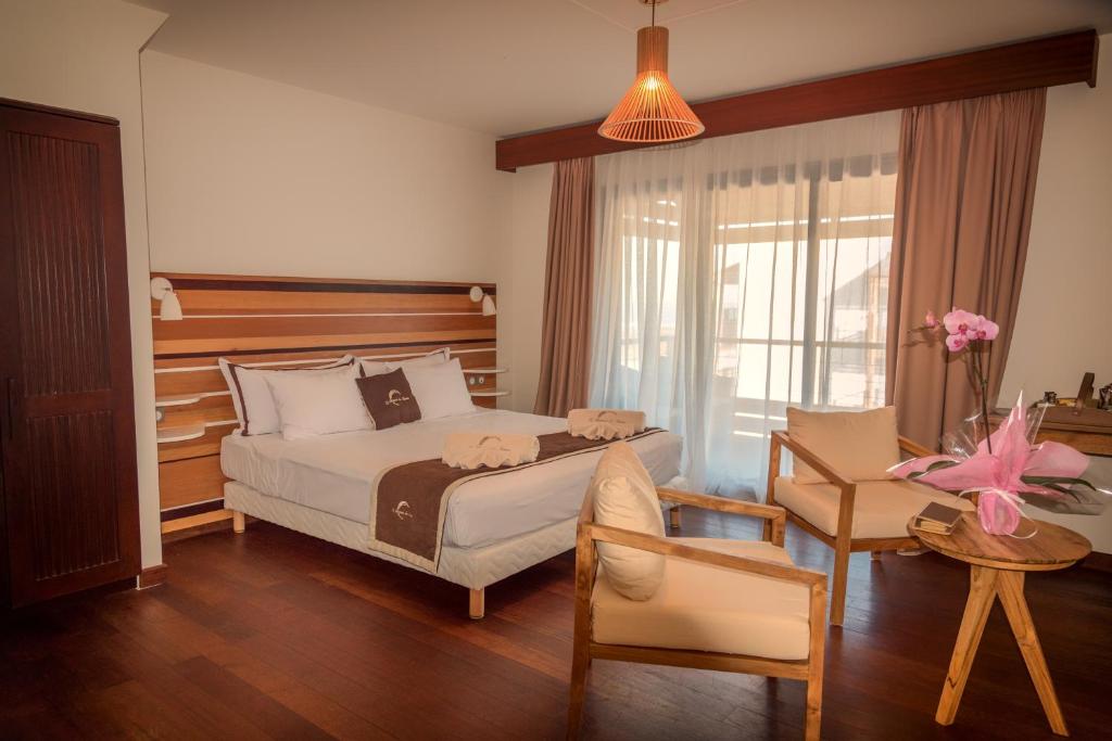 Chambre double supérieure du Battant des Lames avec lit double, fauteuils et baie vitrée sur le balcon