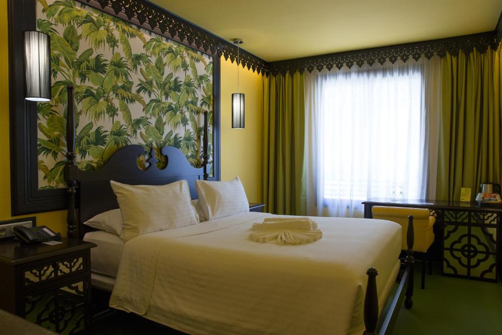 Suite de la Villa Delisle avec mur rouge, double vasque en pierre brute, miroir doré et lit double