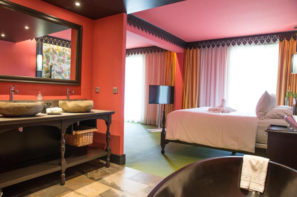Terrasse piscine de la Villa Delisle avec fauteuils en résine tressée, table basse et palmiers ensoleillés