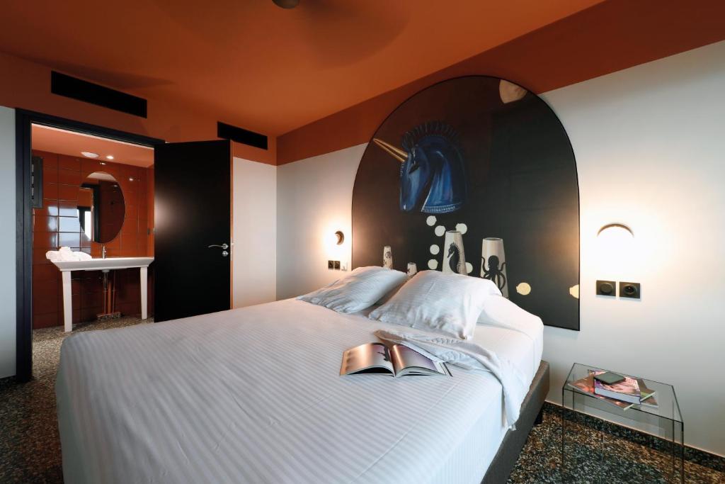 Chambre du Dina Morgabine avec lit double, tête de lit ovale décor licorne marine et plafond orange