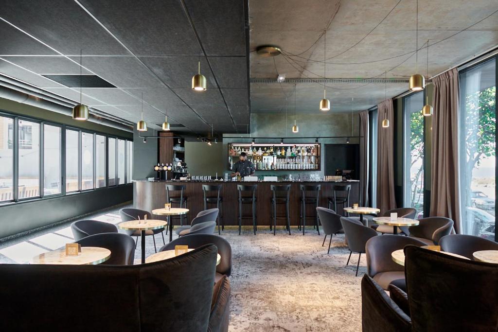 Bar lounge du Dina Morgabine avec comptoir, suspensions dorées, sélection de bouteilles et fauteuils velours