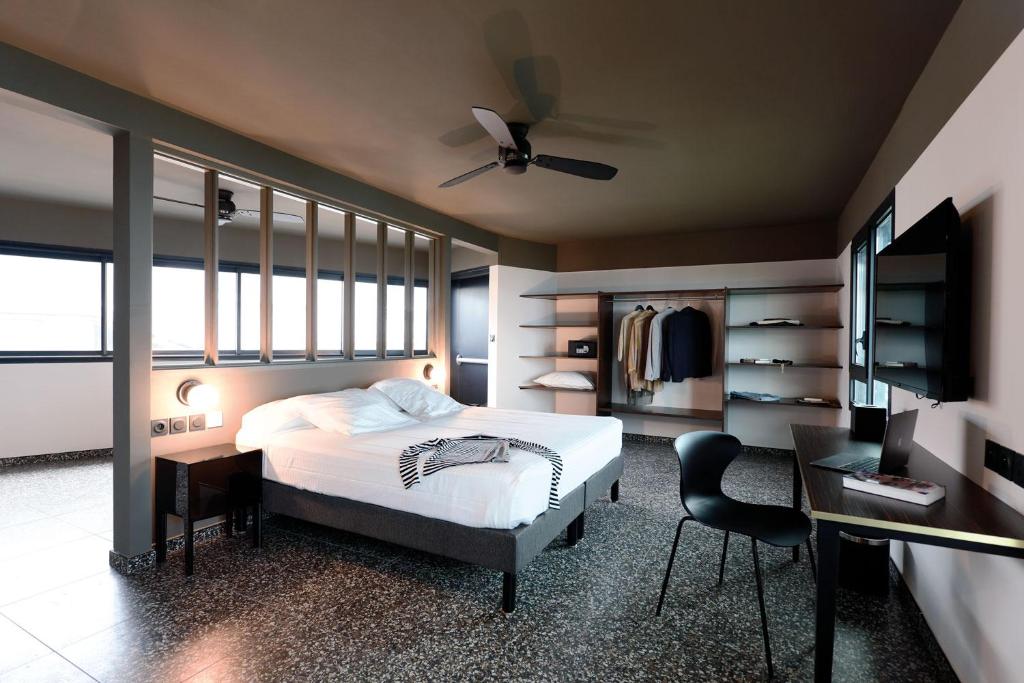 Chambre Standard du Dina Morgabine avec lit double, ventilateur au plafond, bureau et grandes baies vitrées