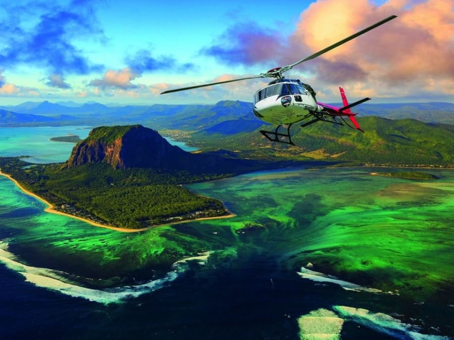 Hélicoptère survolant Le Morne et le lagon turquoise de l'île Maurice