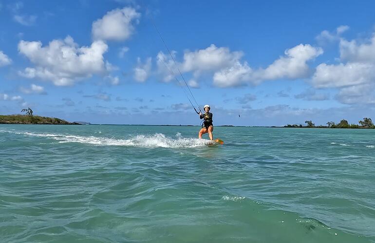 Kitesurfer sur le lagon turquoise de l'île Maurice, voile en hauteur, planche en glisse