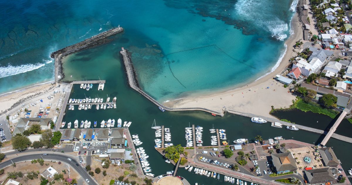 Saint-Gilles-les-Bains marina in Reunion Island with pleasure boats, a jetty and sunset over the ocean