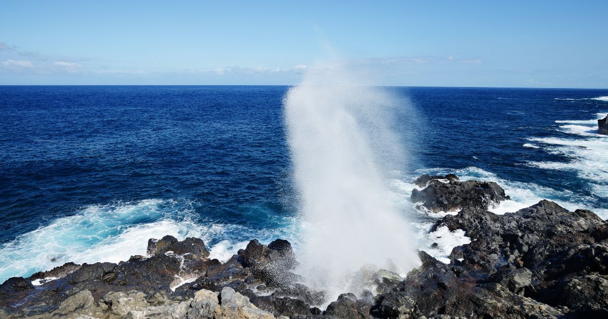 Vague qui explose en geyser sur les rochers basaltiques de la Pointe au Sel à Saint-Leu, La Réunion