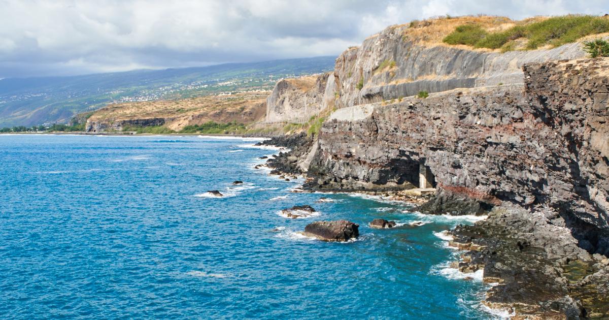 Côte sauvage de La Réunion en janvier : falaises de basalte et océan turquoise sous un ciel d'été austral