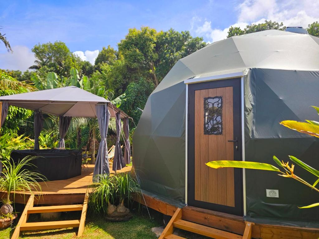 Dôme géodésique vert sur terrasse en bois avec pergola et bain nordique au Domaine de Petite-Île