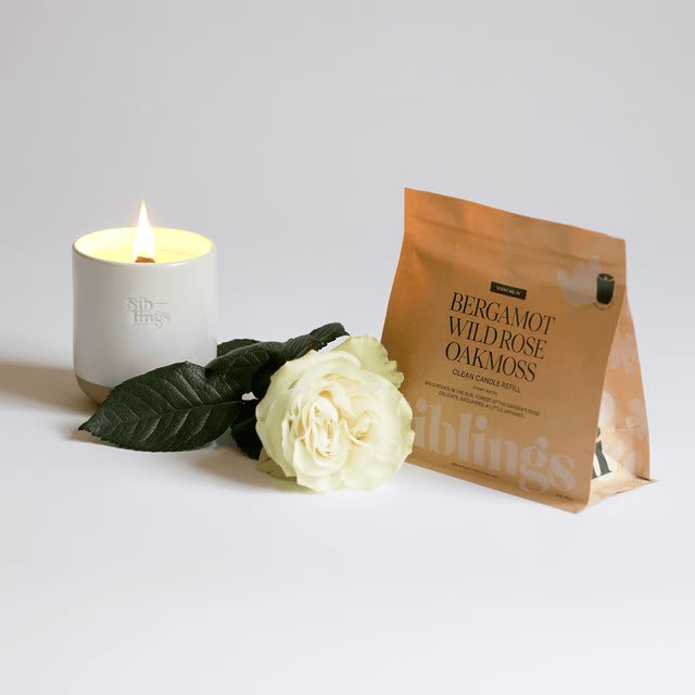 A Siblings candle poured into its ceramic vessel, beside the compostable refill pouch it came in.