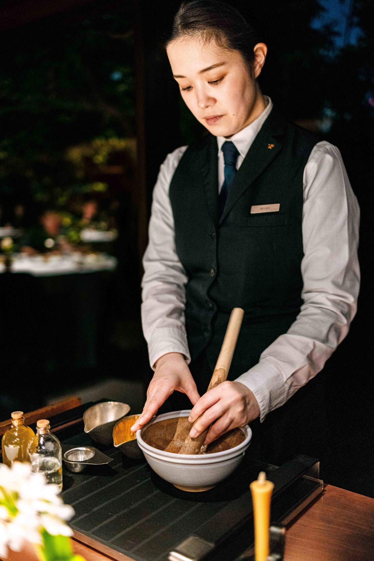 L'Effervescence, Tokyo: a server showing the tea leaves, mixing the cocktail and pouring it out