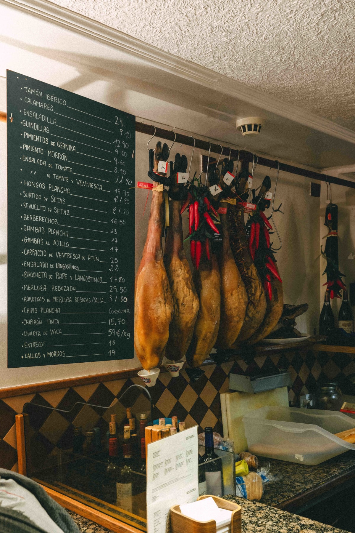 Ganbara, San Sebastián: the board inside with hams hanging beside it