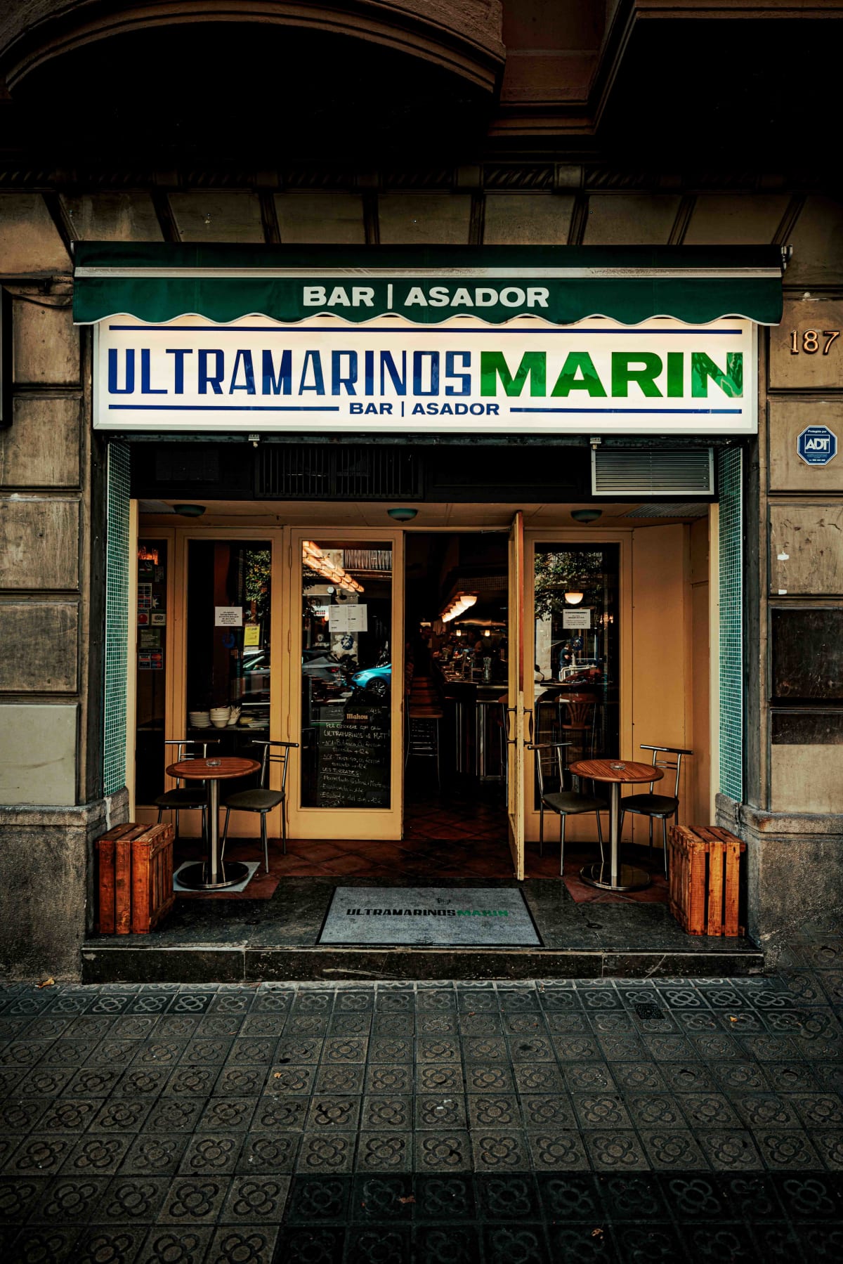 Ultramarinos Marín, Barcelona: the green awning and the bar asador sign at number 187
