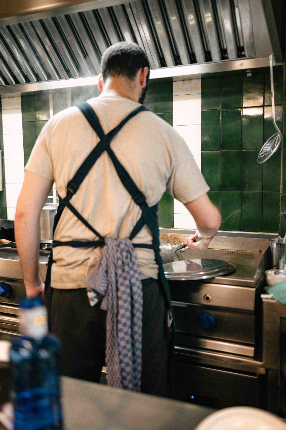 Ultramarinos Marín, Barcelona: a cook working the planxa