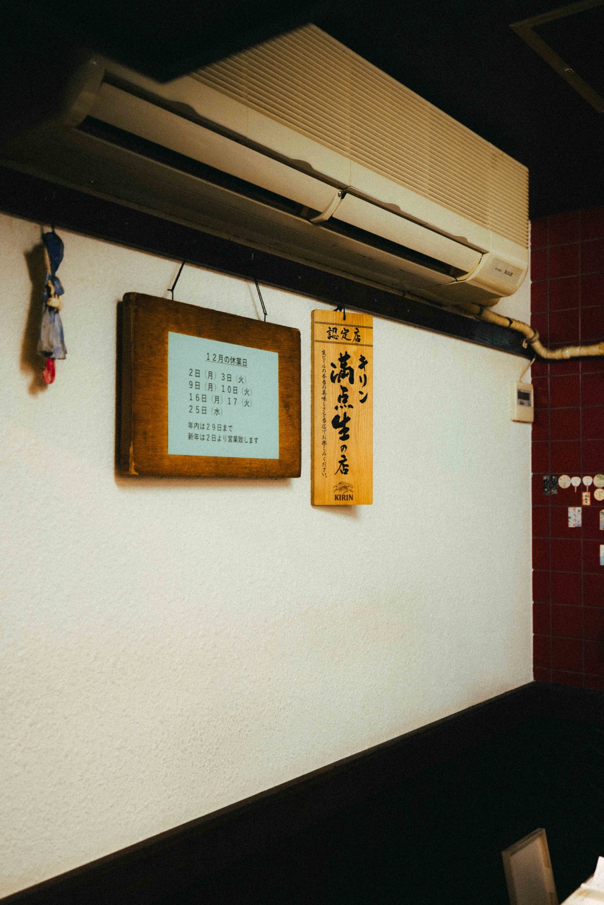 Kuishinbo Yamanaka, Kyoto: the Kirin draft beer plaque on the wall beside the December closing days