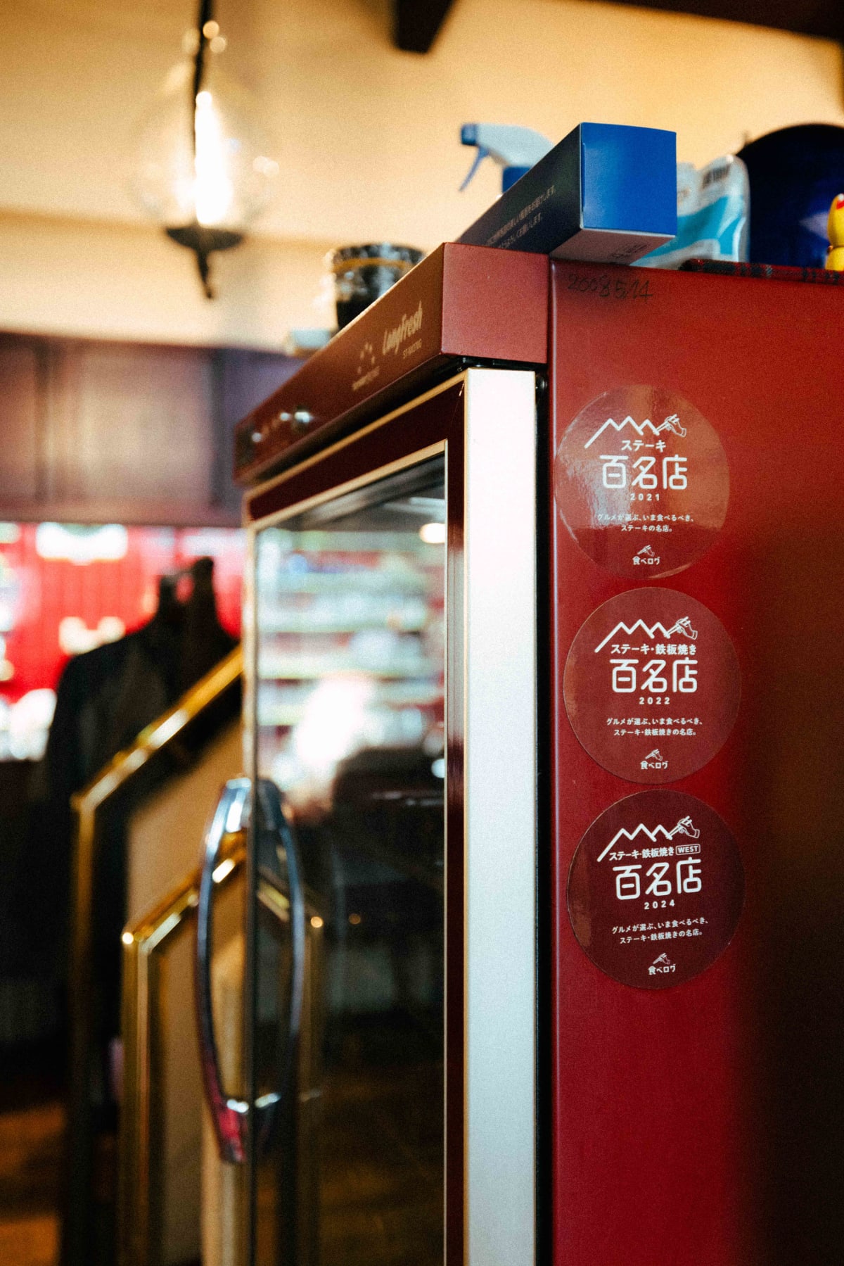 Kuishinbo Yamanaka, Kyoto: the Tabelog Hyakumeiten stickers for 2021, 2022 and 2024 on the fridge
