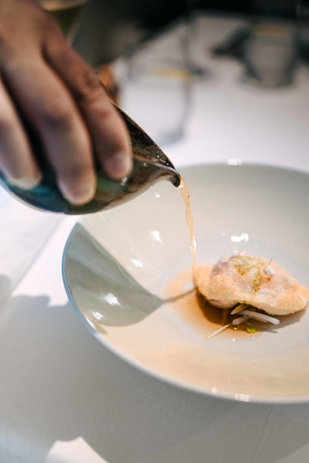 JEE, Hong Kong: the bouillon poured around the fried langoustine dumpling at the table