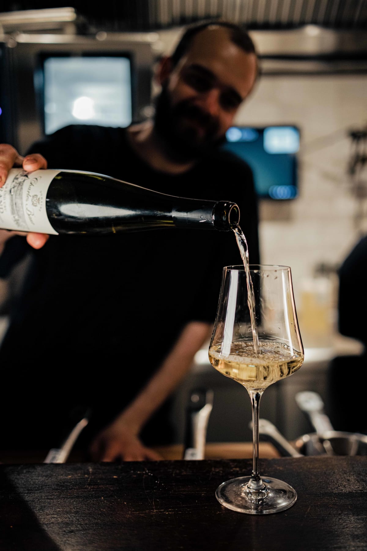 Bistro de la Mer, Amsterdam: the server pouring the Riesling, one arm on the counter