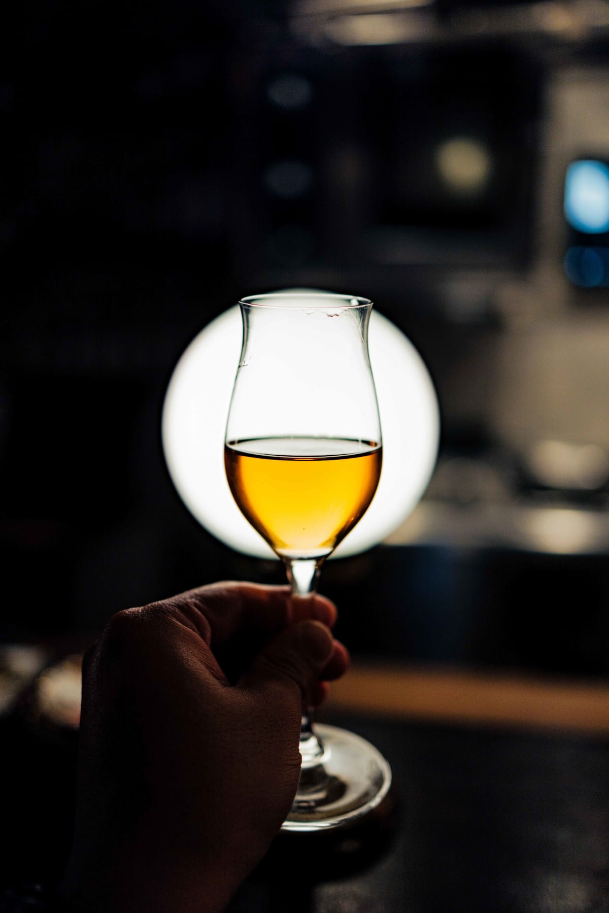 Bistro de la Mer, Amsterdam: the glass of Zantho held up against a globe lamp