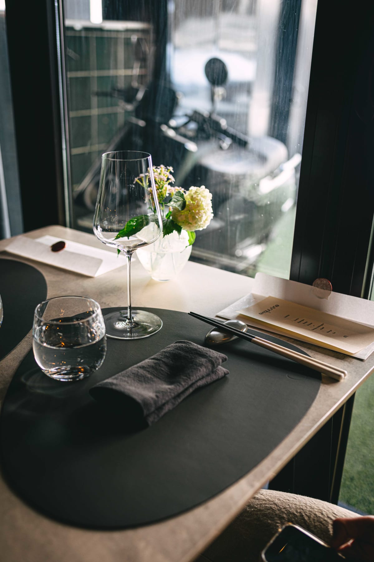 Exquisine, Seoul: the table laid for lunch by the window, with a small vase of white flowers and the wax-sealed menu