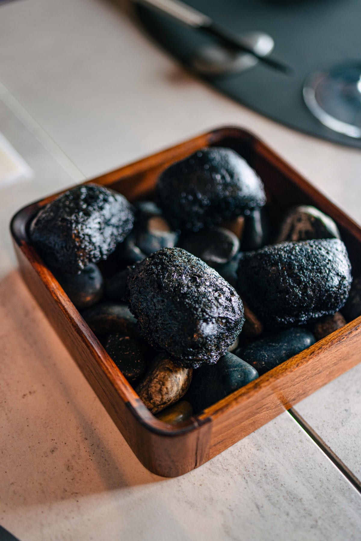 Exquisine, Seoul: the signature fish fry, dark-crusted pieces set among river pebbles in a wooden box