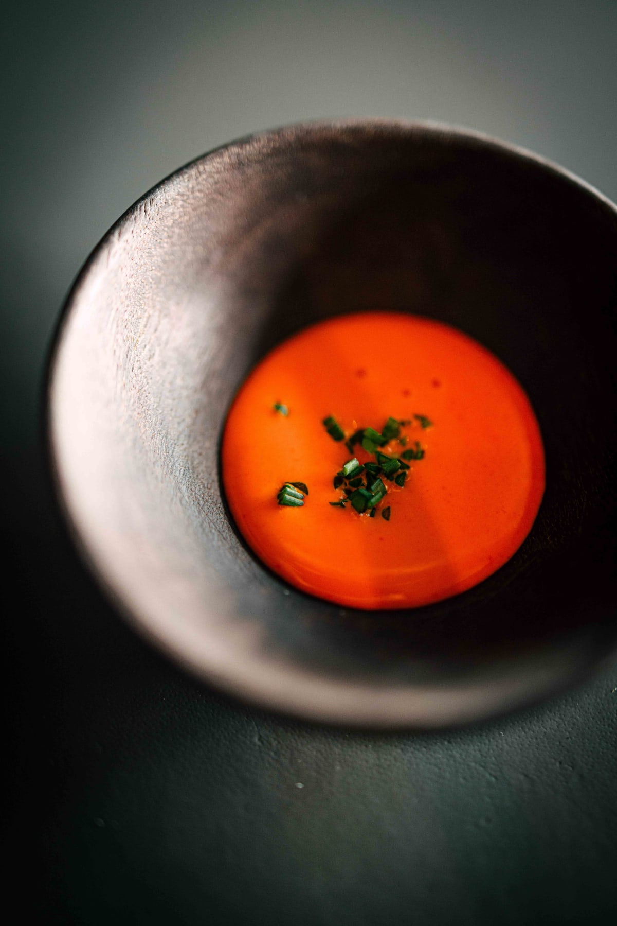 Exquisine, Seoul: a small dark bowl of bright orange sauce, scattered with chives