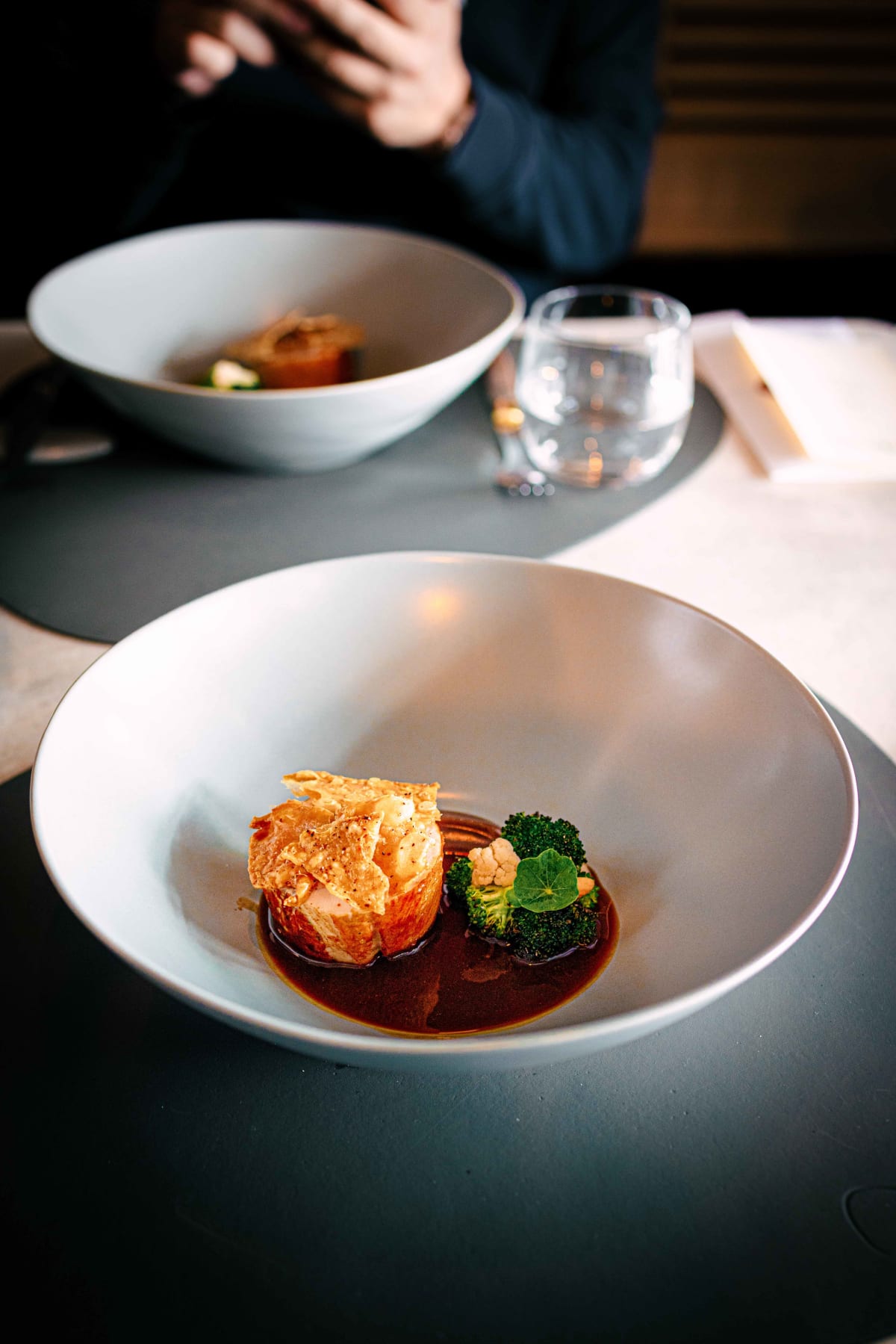 Exquisine, Seoul: the chicken with a crisp wafer on top, a glossy dark sauce, broccoli and cauliflower, a second bowl beyond