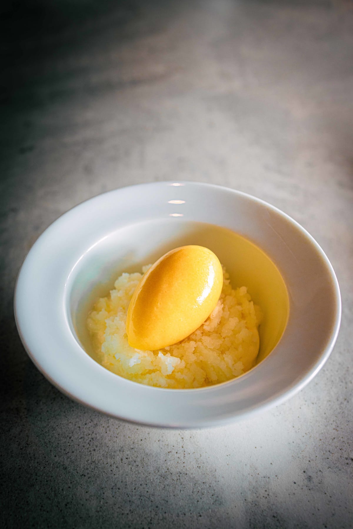 Exquisine, Seoul: the mango dessert, a quenelle of mango ice cream over mango mousse in a white bowl