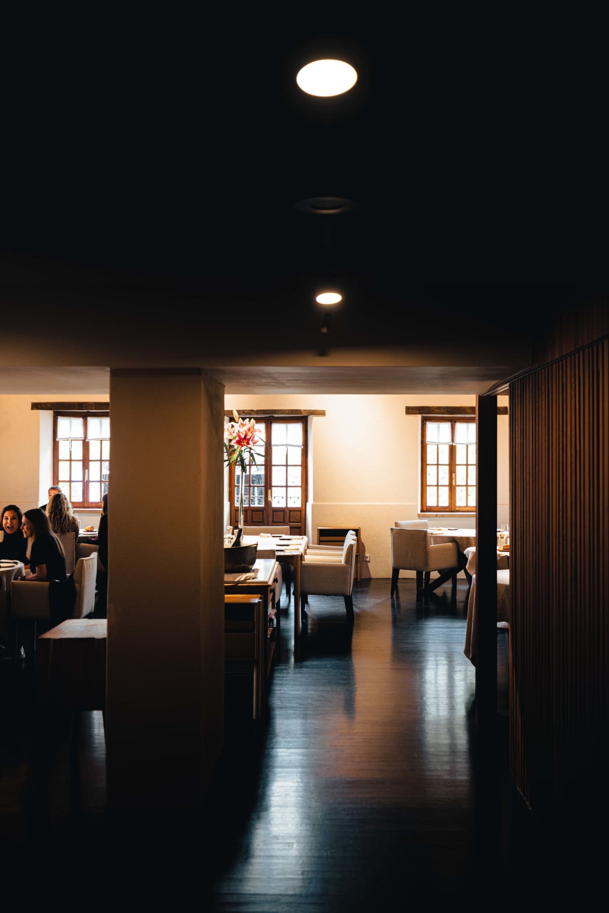 Asador Etxebarri, Axpe: the upstairs dining room seen past a pillar, guests at the window tables