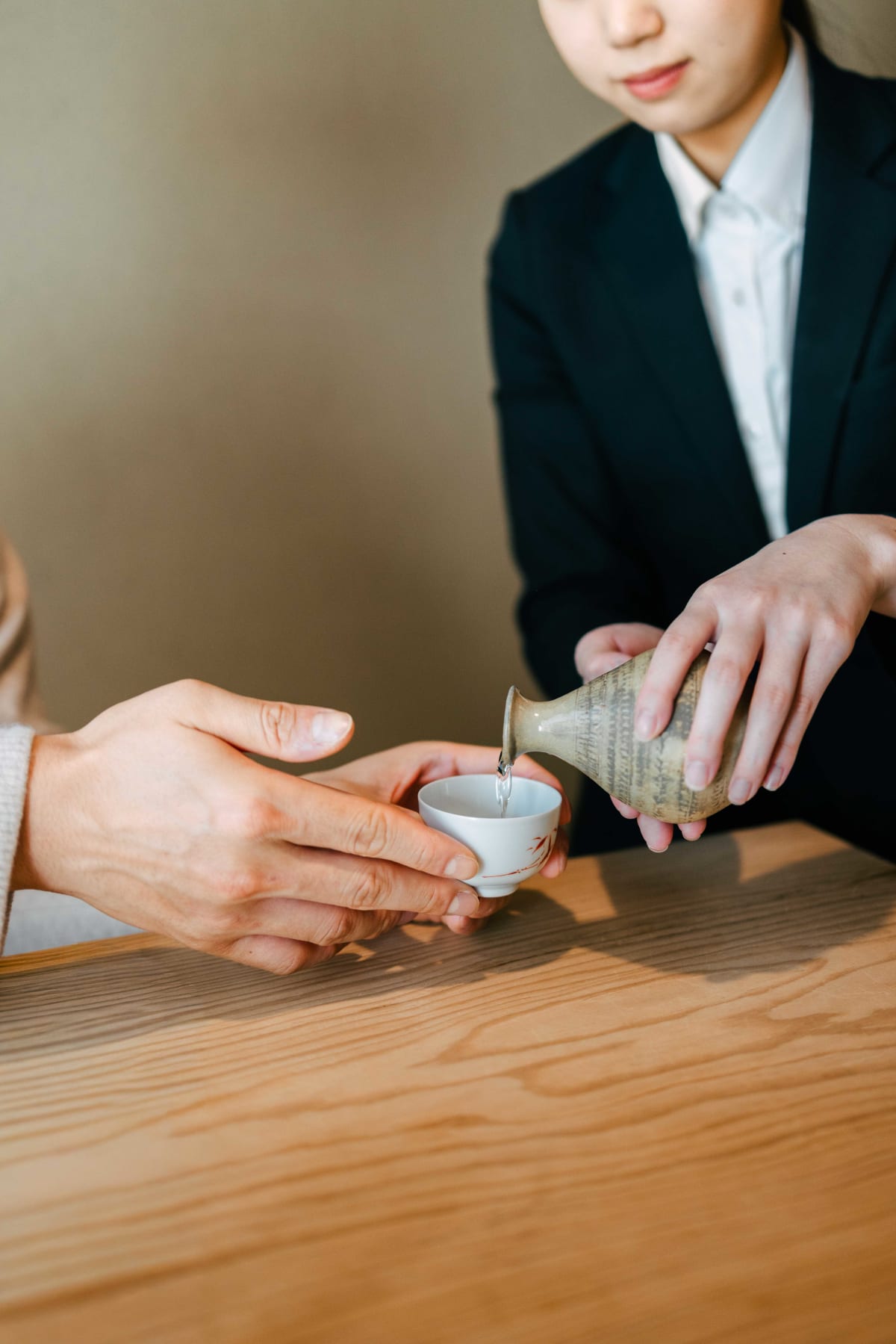 Matsukawa, Tokyo: a member of staff pouring sake at our table