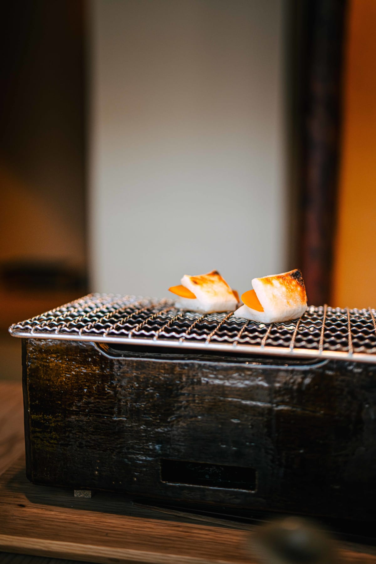 Matsukawa, Tokyo: karasumi mochi toasting over a small brazier, grilled by a member of staff in our room
