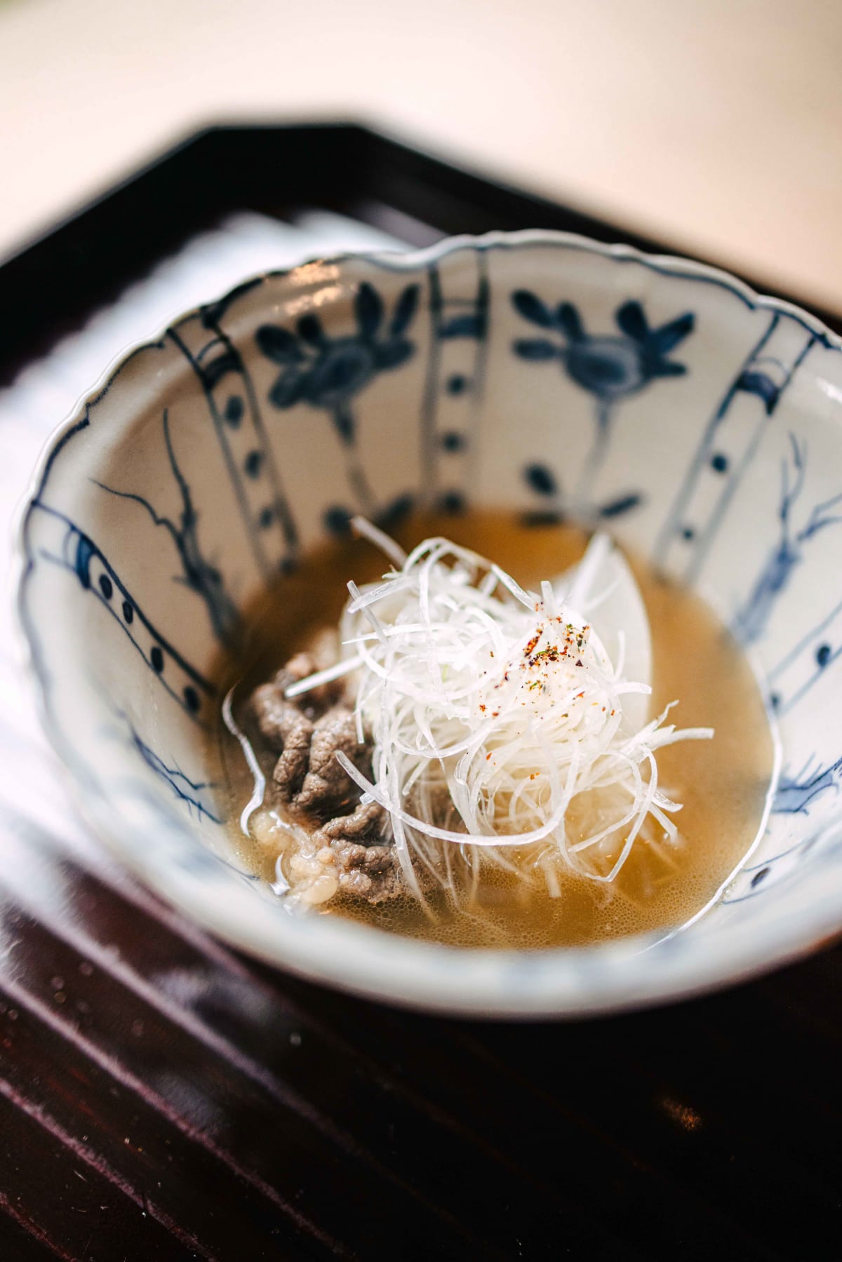 Matsukawa, Tokyo: bear meat in broth with daikon and shredded white leek, in a blue and white bowl