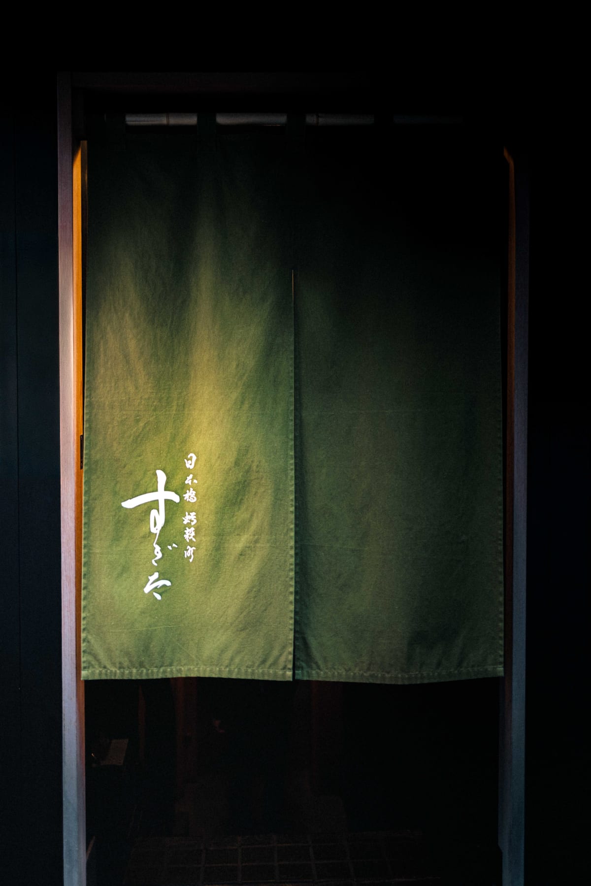 Nihonbashi Kakigaracho Sugita, Tokyo: the noren hanging in the doorway, its green deepening towards the hem