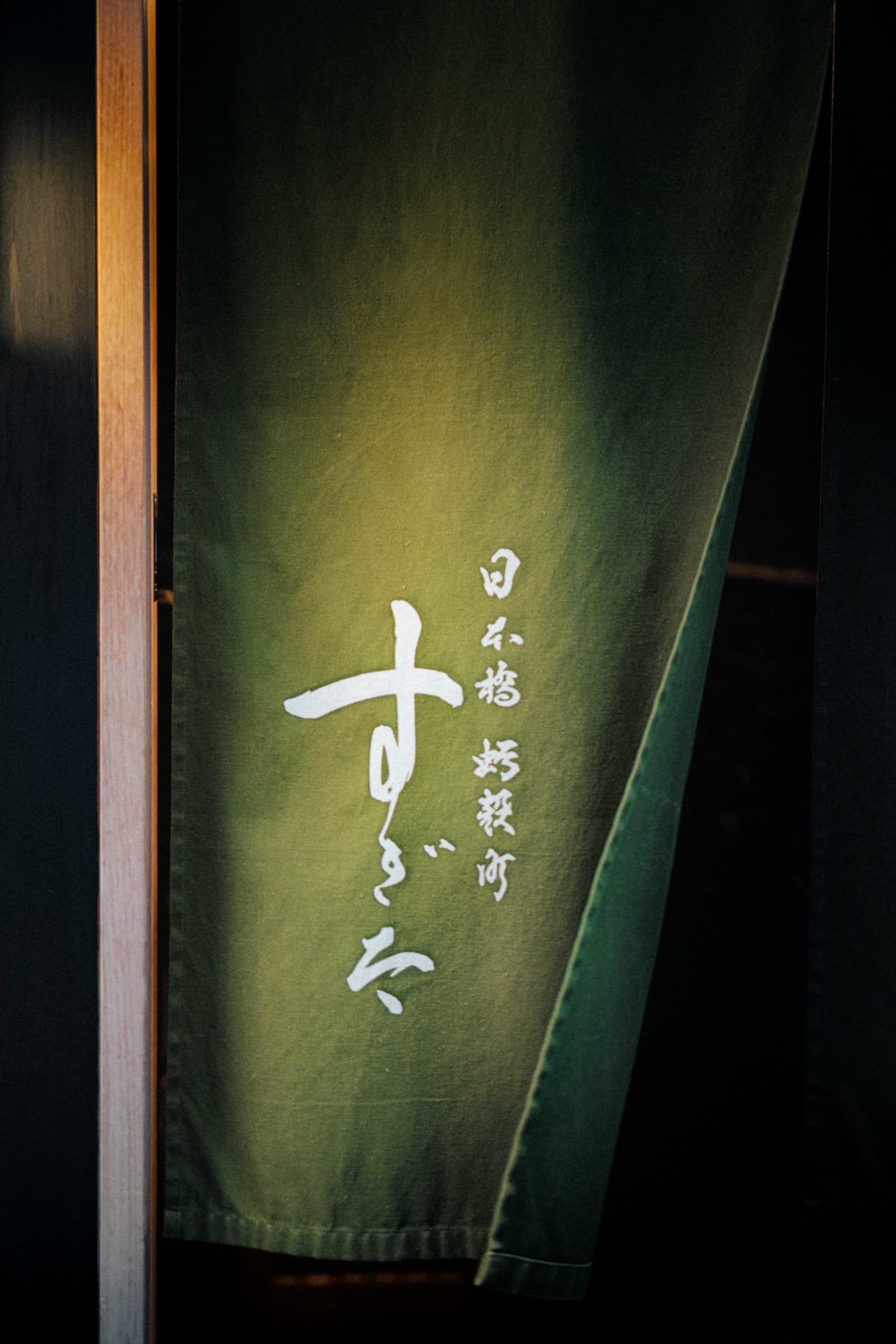 Nihonbashi Kakigaracho Sugita, Tokyo: the green noren at the entrance, 日本橋 蛎殻町 すぎた brushed on it in white