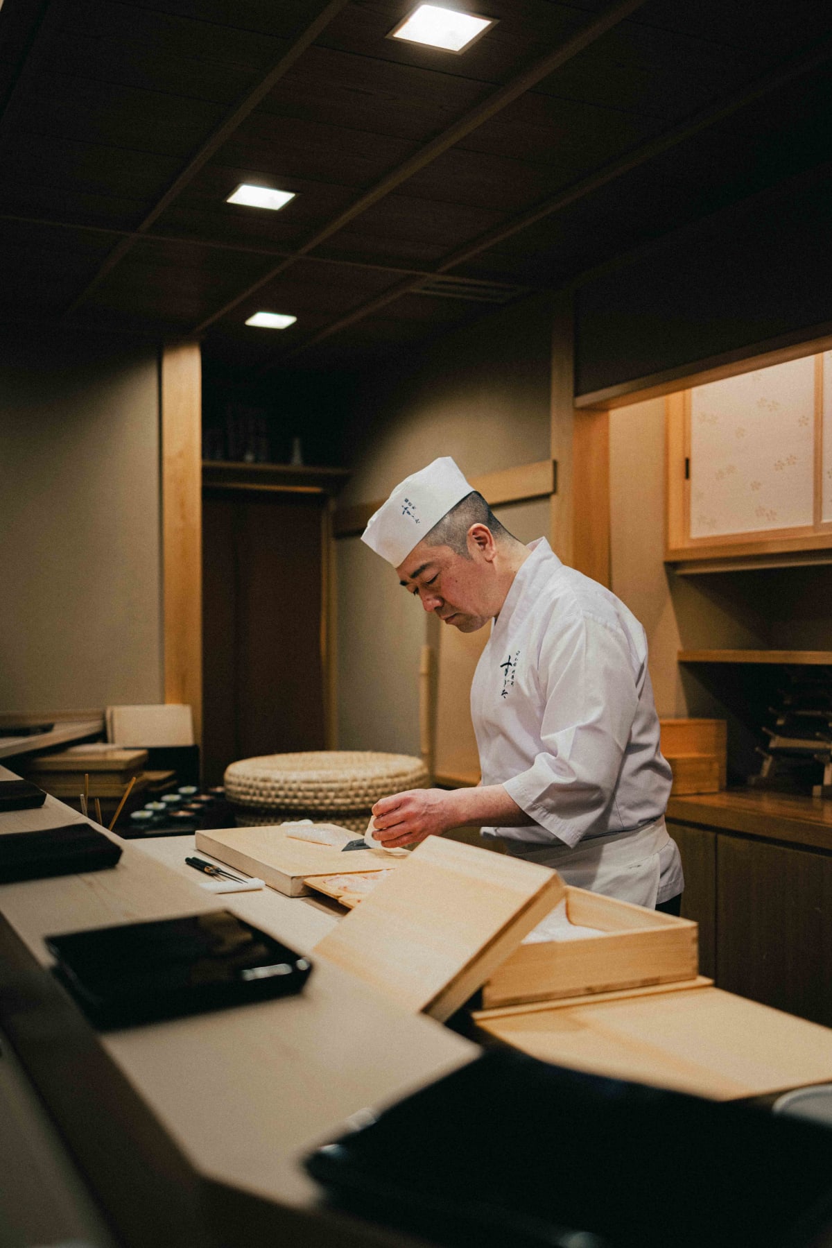 Nihonbashi Kakigaracho Sugita, Tokyo: Sugita behind the counter preparing the tsumami, the rice tub and neta boxes around him