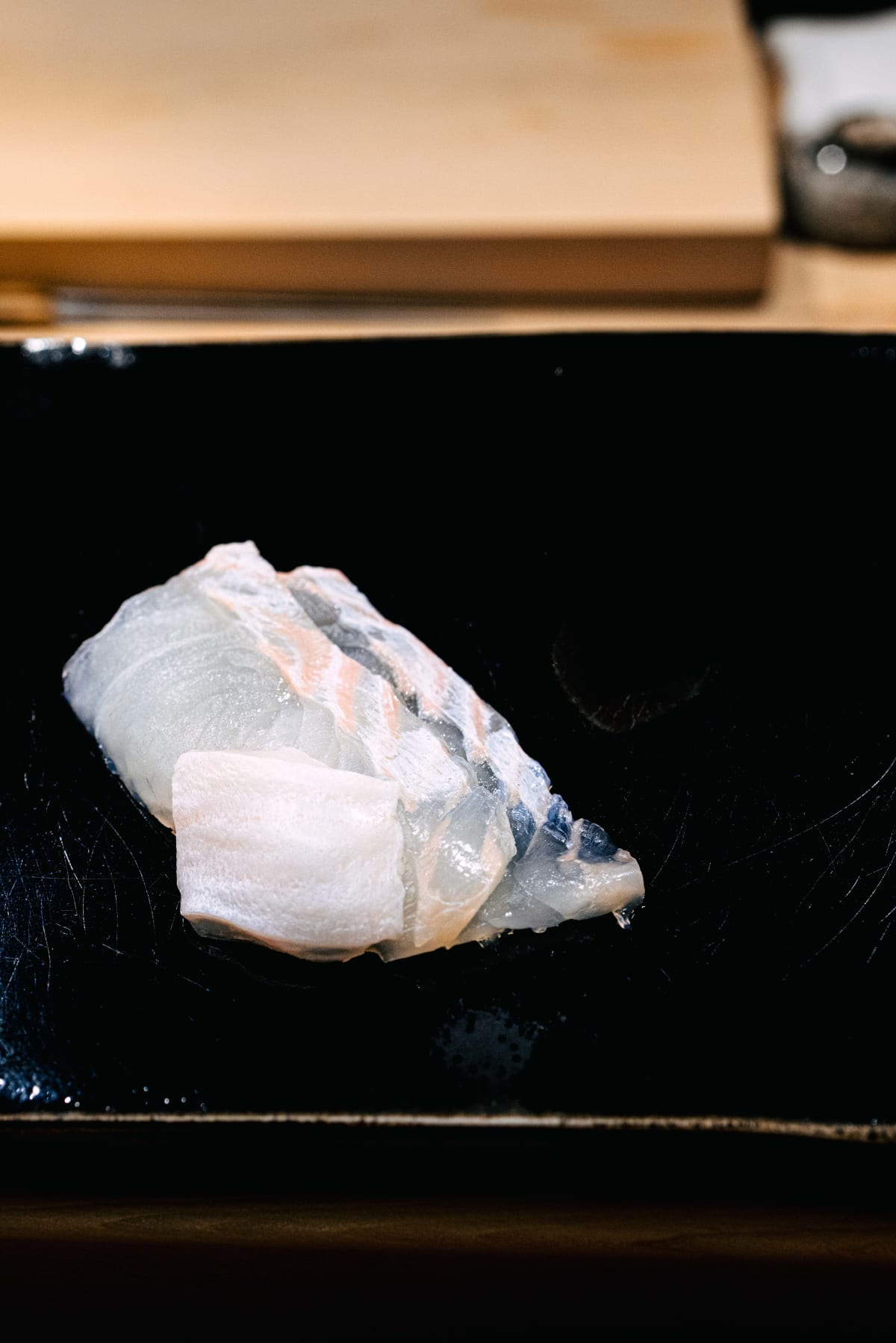 Nihonbashi Kakigaracho Sugita, Tokyo: hirame sashimi on the black lacquer board, thin translucent slices with a thicker piece in front