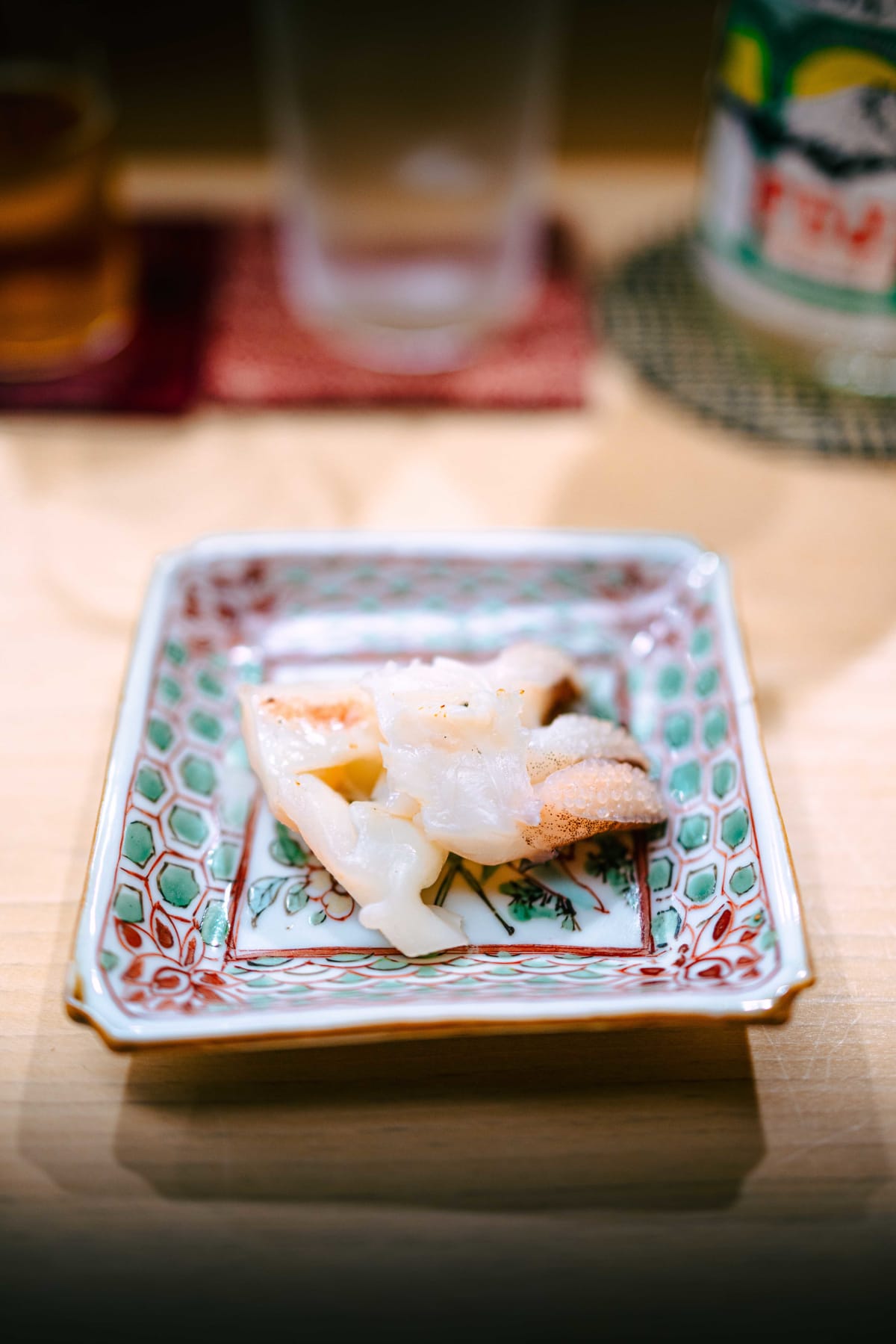 Nihonbashi Kakigaracho Sugita, Tokyo: the grilled sumi-ika legs, lightly browned at the suckers, on a square overglaze dish patterned with green hexagons