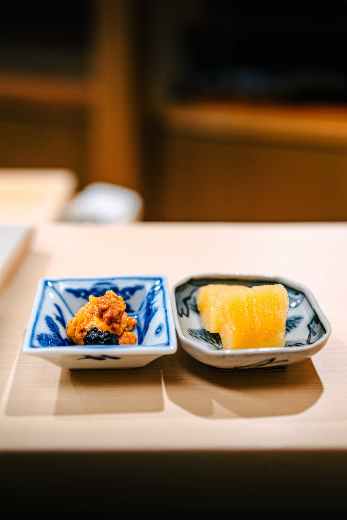 Nihonbashi Kakigaracho Sugita, Tokyo: two small dishes side by side, uni with a dark, glossy relish and two slabs of kazunoko