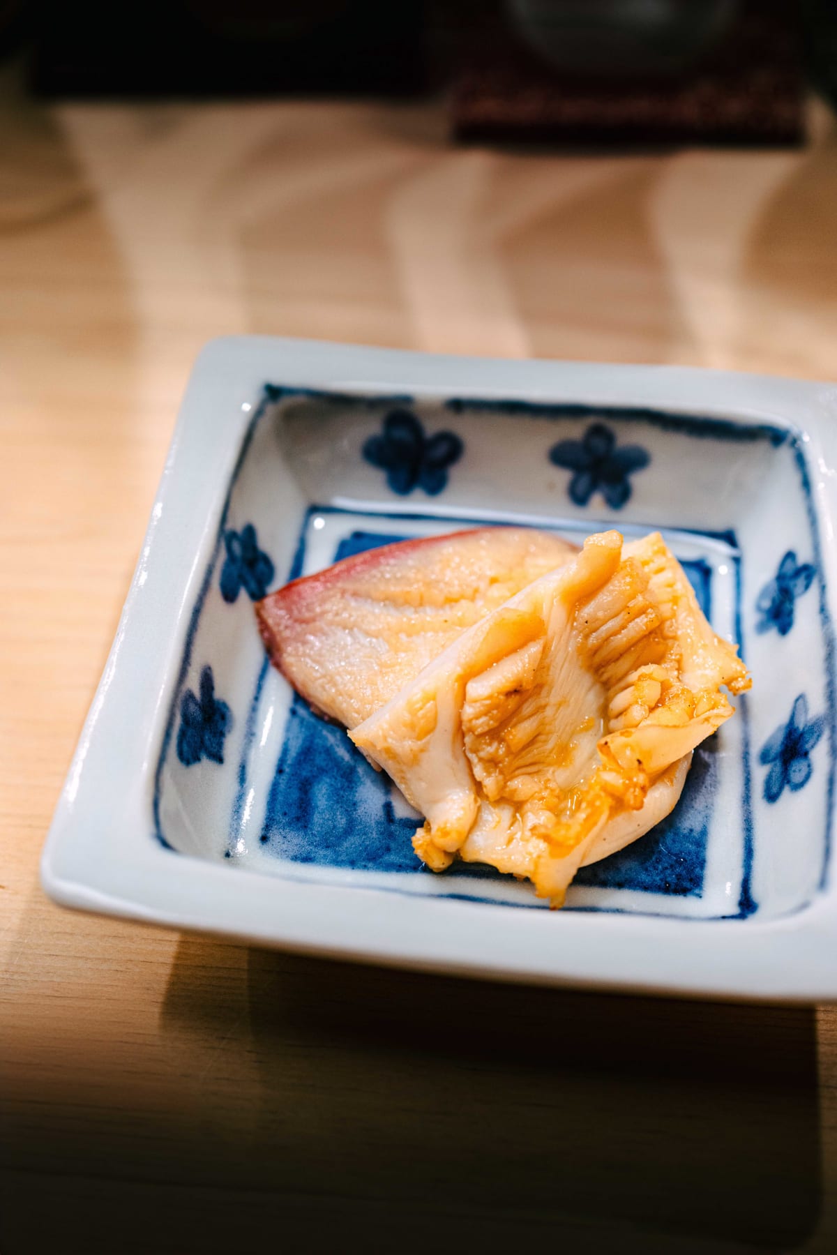 Nihonbashi Kakigaracho Sugita, Tokyo: hokkigai, lightly grilled, its tip turned a deep pink, in a square dish painted with blue blossoms